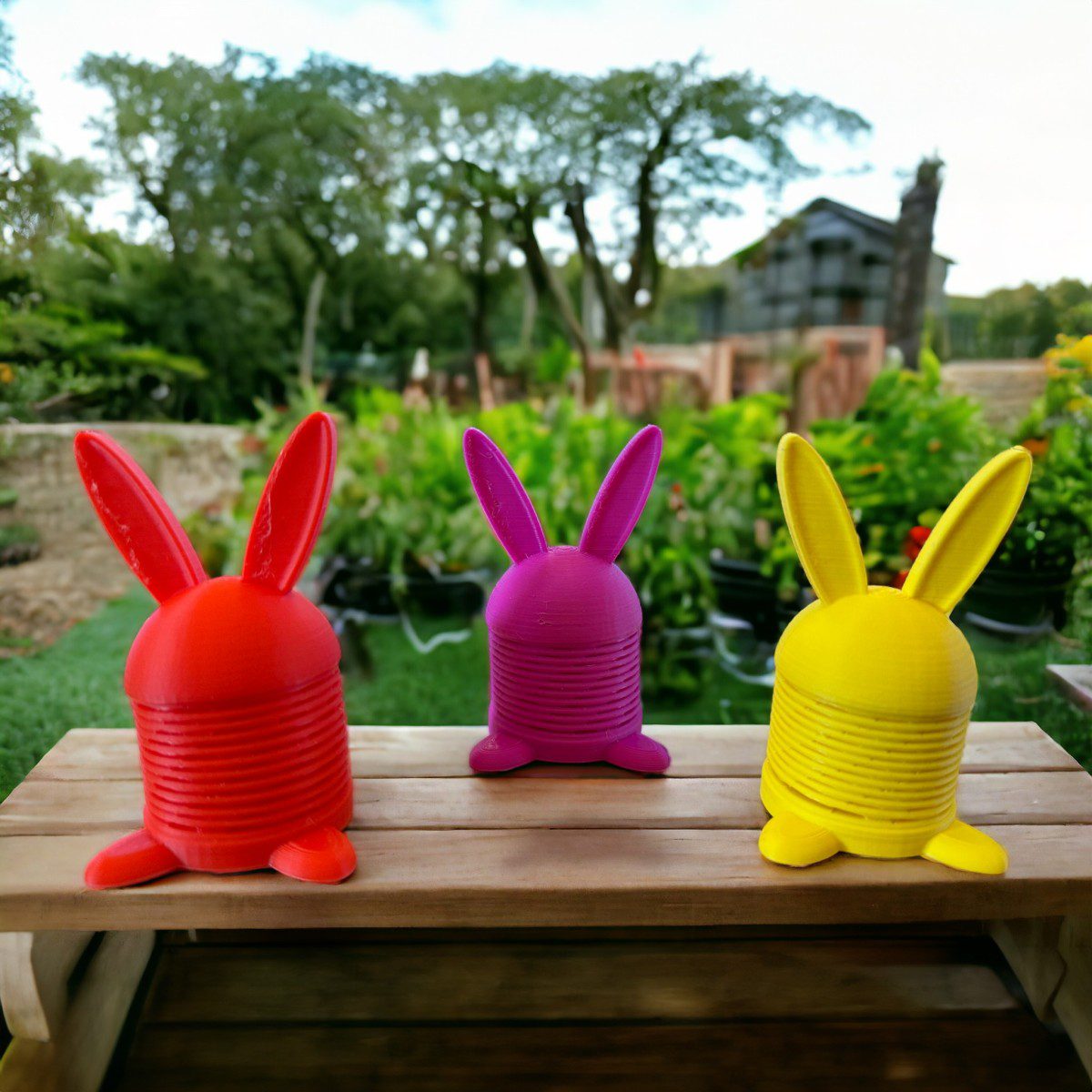 Three bouncing bunnys on a wooden table outside